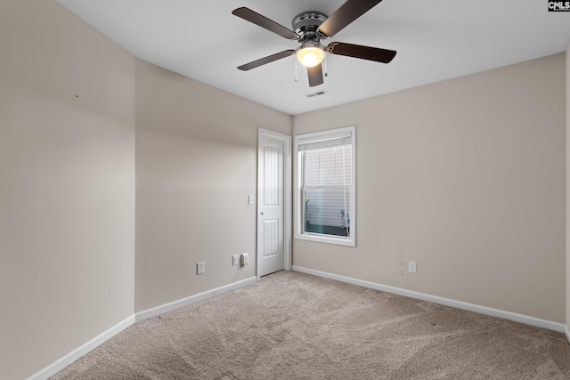 carpeted spare room featuring ceiling fan