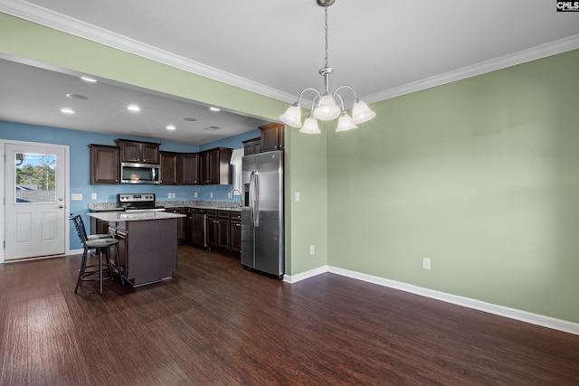 kitchen with a center island, appliances with stainless steel finishes, hanging light fixtures, dark brown cabinetry, and a breakfast bar