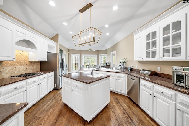 106 Stonebrook Dr, Blythewood, SC 29016 - kitchen with white cabinets, stainless steel appliances, dark stone countertops, backsplash, and hanging light fixtures
