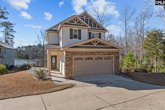 view of front of property with a garage and a water view