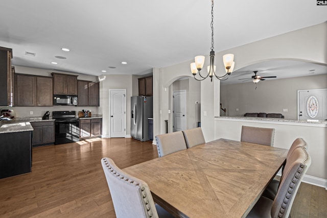 dining room with ceiling fan with notable chandelier, dark hardwood / wood-style floors, and sink