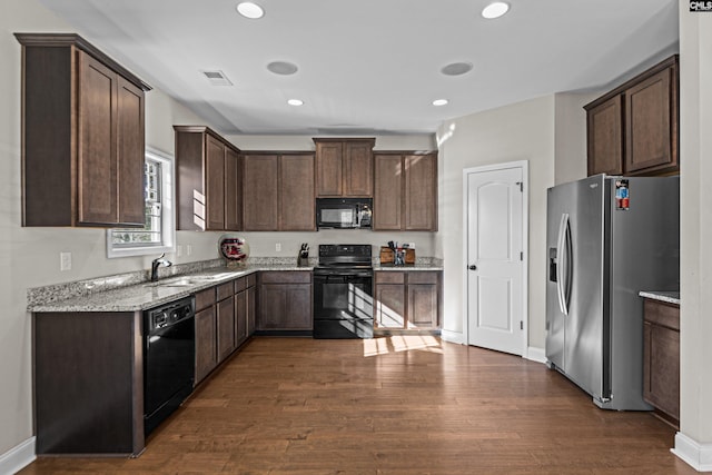 kitchen featuring sink, dark wood-type flooring, dark brown cabinets, and black appliances