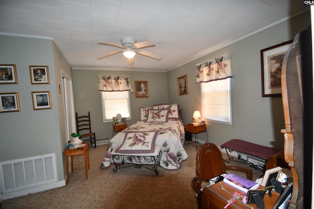 carpeted bedroom with ornamental molding and ceiling fan