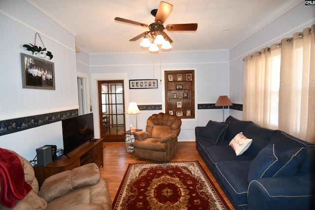 living room with hardwood / wood-style flooring, crown molding, and ceiling fan