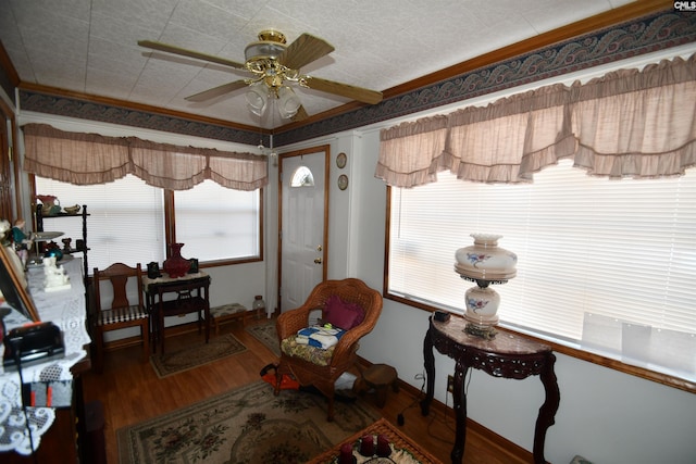 living area with ornamental molding, plenty of natural light, hardwood / wood-style floors, and ceiling fan