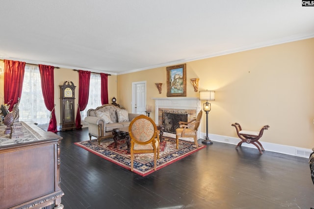 living room featuring dark hardwood / wood-style flooring, crown molding, and a premium fireplace
