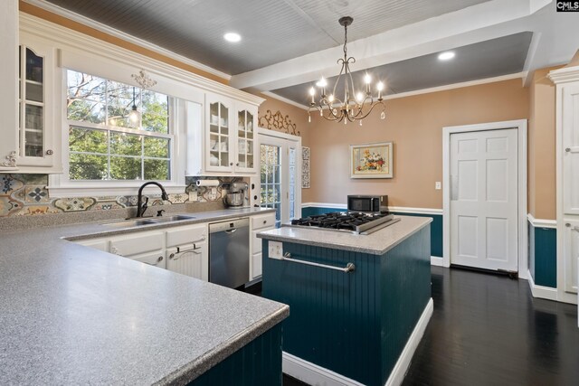 kitchen featuring a center island, appliances with stainless steel finishes, white cabinetry, hanging light fixtures, and sink