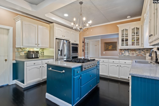 kitchen featuring hanging light fixtures, sink, light stone counters, a kitchen island, and stainless steel appliances