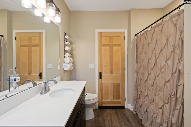 bathroom with a shower with curtain, hardwood / wood-style flooring, toilet, and vanity