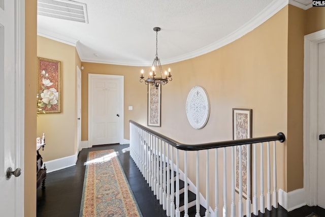 hall featuring dark hardwood / wood-style flooring, a chandelier, and ornamental molding