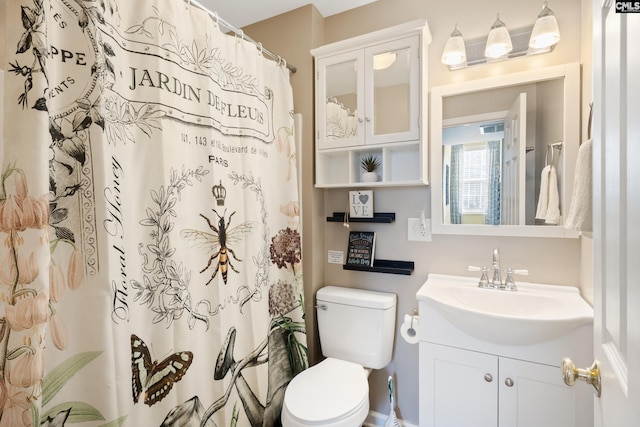 bathroom with toilet, a shower with shower curtain, and vanity