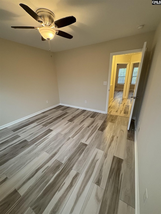 spare room with ceiling fan and light wood-type flooring