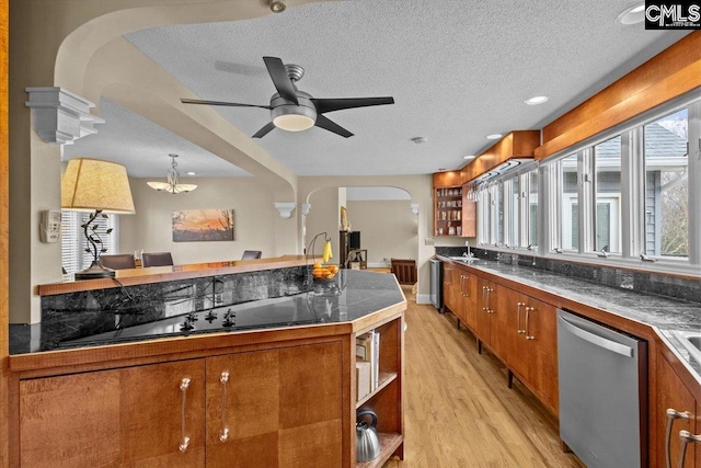 kitchen featuring pendant lighting, ceiling fan, light hardwood / wood-style floors, a textured ceiling, and stainless steel dishwasher