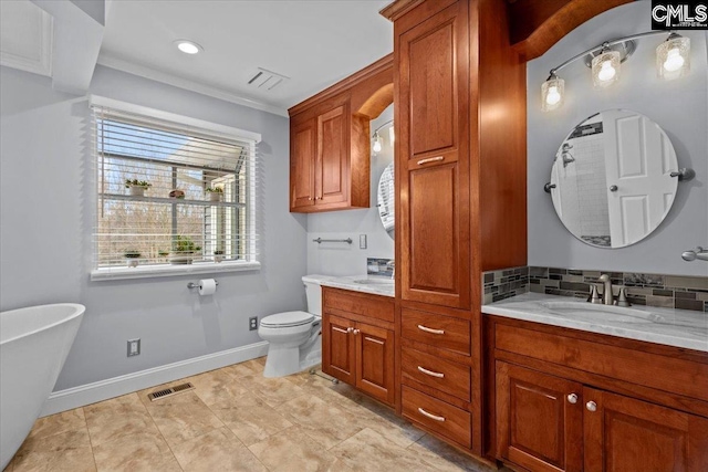 bathroom with a tub to relax in, ornamental molding, toilet, and vanity