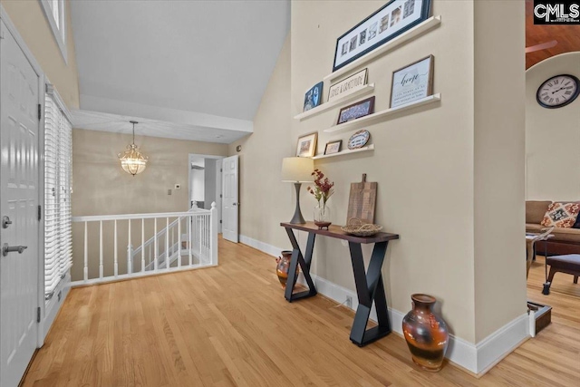 hallway with a towering ceiling and light wood-type flooring