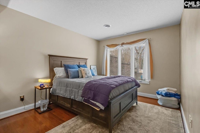 bedroom with hardwood / wood-style flooring and a textured ceiling