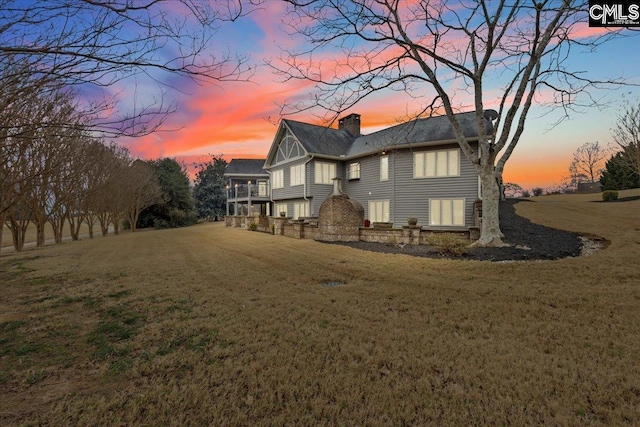 back house at dusk with a lawn