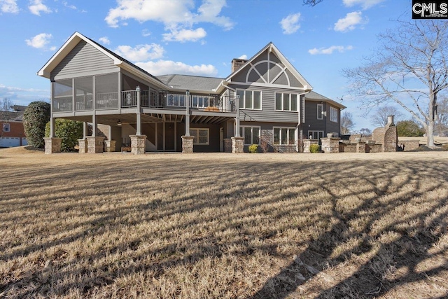 back of house with a yard, a deck, and a sunroom