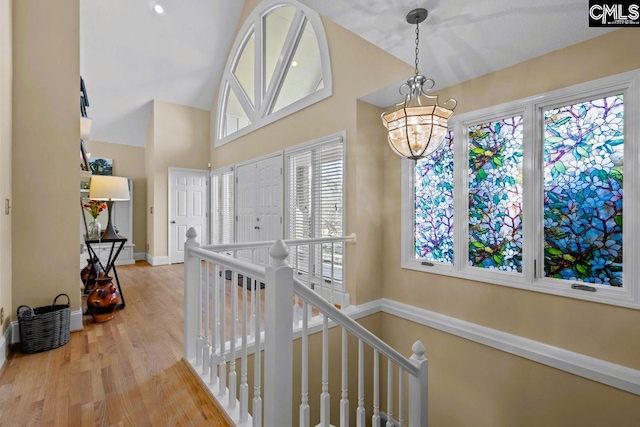 hall with wood-type flooring and a notable chandelier