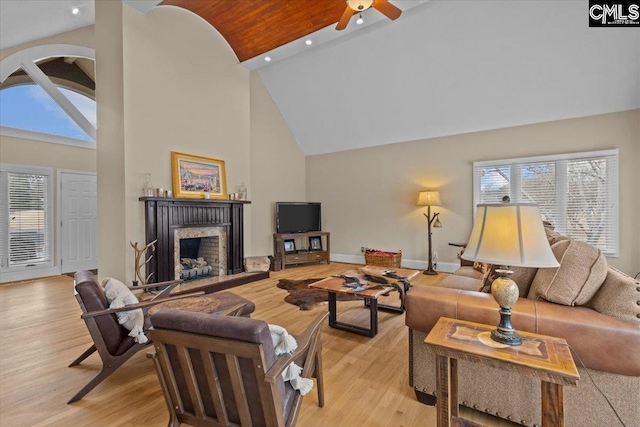 living room with ceiling fan, plenty of natural light, light hardwood / wood-style floors, and high vaulted ceiling