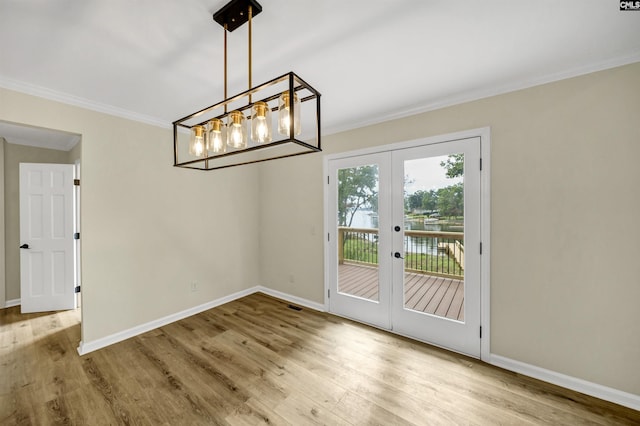 unfurnished dining area featuring french doors, crown molding, and light hardwood / wood-style floors