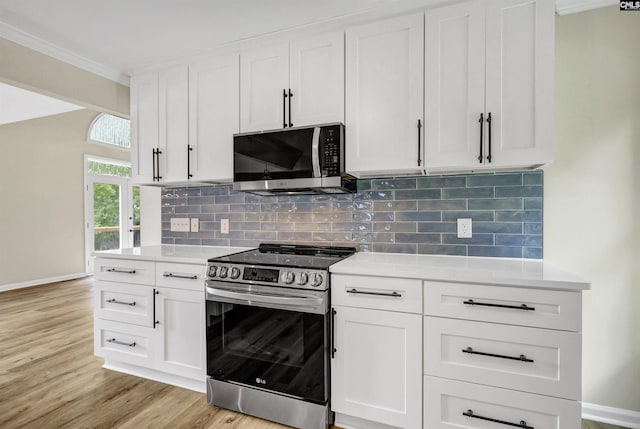 kitchen with backsplash, white cabinets, light wood-type flooring, and stainless steel appliances