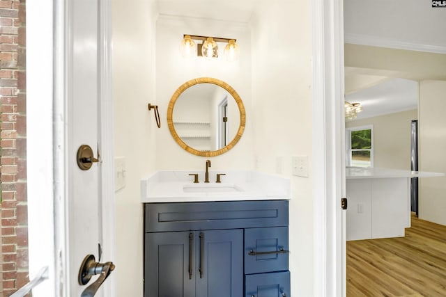 bathroom with wood-type flooring, vanity, and ornamental molding