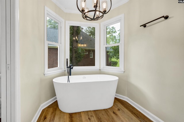 bathroom featuring hardwood / wood-style floors, crown molding, and a bathing tub