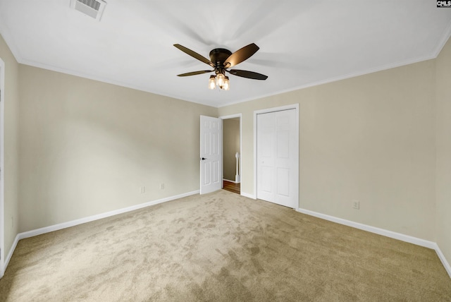 unfurnished bedroom featuring carpet flooring, a closet, ceiling fan, and ornamental molding