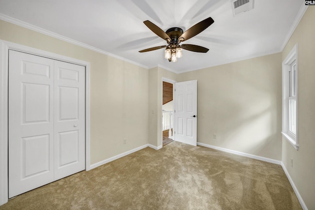 unfurnished bedroom with light colored carpet, a closet, ceiling fan, and ornamental molding