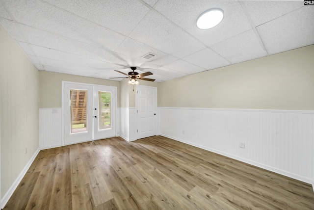 spare room featuring ceiling fan, wood-type flooring, and a paneled ceiling