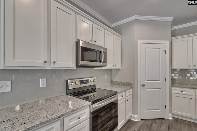 kitchen with white cabinetry, ornamental molding, stainless steel appliances, and dark hardwood / wood-style floors