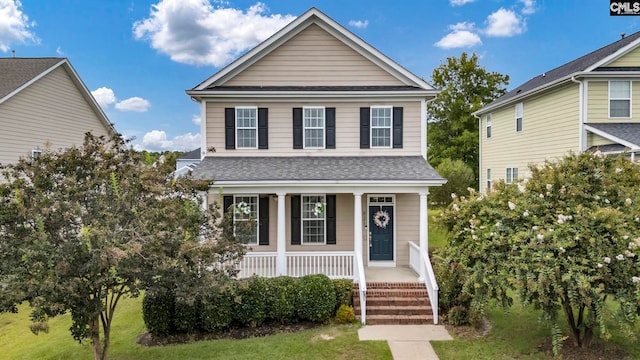 view of property featuring covered porch and a front lawn