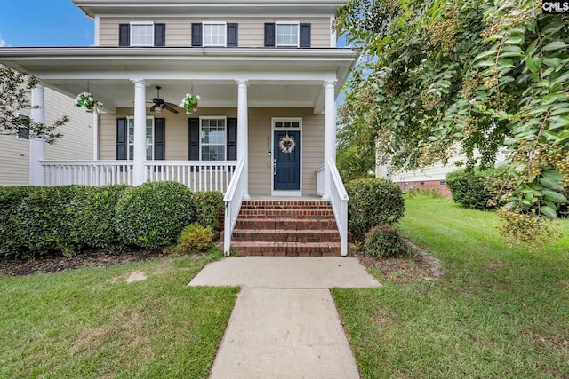 view of front of property with covered porch, ceiling fan, and a front yard