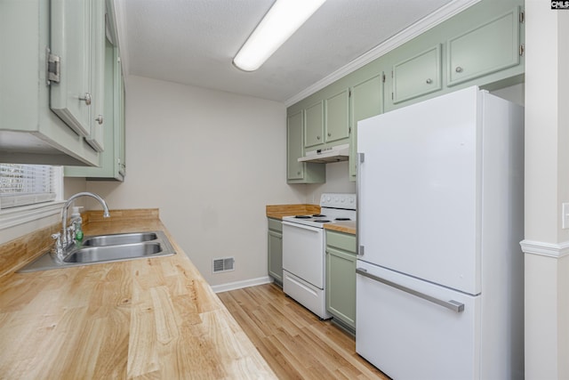 kitchen featuring white appliances, a textured ceiling, sink, green cabinets, and light hardwood / wood-style flooring