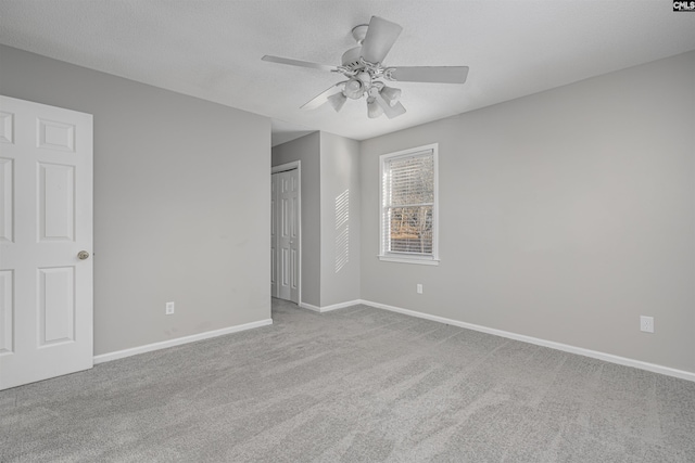 carpeted spare room featuring ceiling fan and a textured ceiling