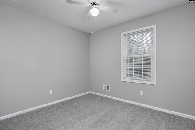 carpeted empty room featuring ceiling fan and a textured ceiling