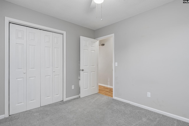 unfurnished bedroom with a closet, ceiling fan, and light carpet