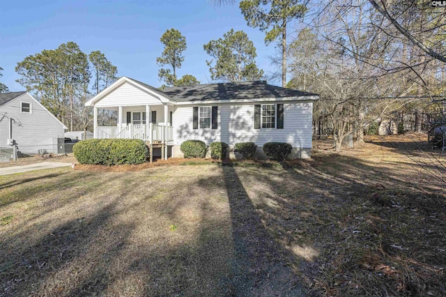 ranch-style home featuring covered porch and a front yard