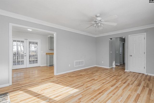 empty room featuring ceiling fan, ornamental molding, french doors, and light wood-type flooring