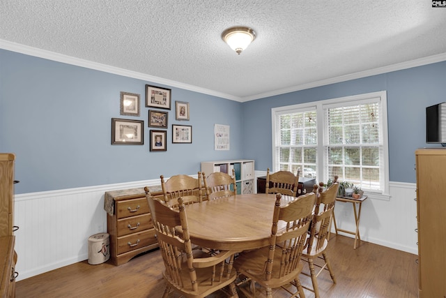 dining area featuring hardwood / wood-style flooring, a textured ceiling, and crown molding