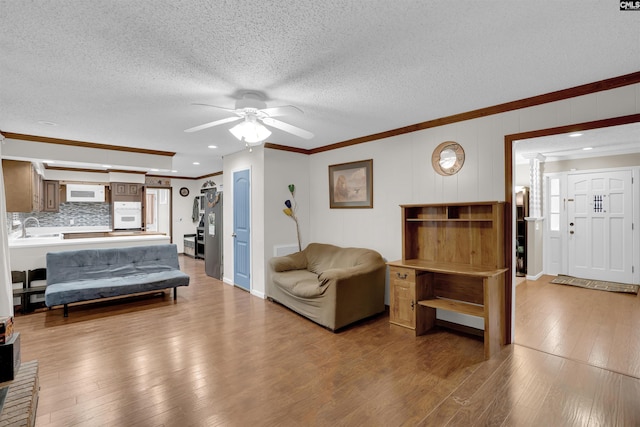 bedroom with sink, ceiling fan, crown molding, and a textured ceiling