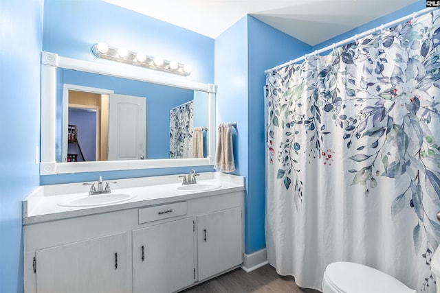 bathroom with hardwood / wood-style floors, toilet, curtained shower, and vanity