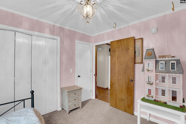 bedroom with a textured ceiling, light carpet, a closet, an inviting chandelier, and ornamental molding