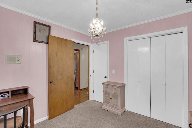 carpeted bedroom with crown molding, an inviting chandelier, a textured ceiling, and a closet