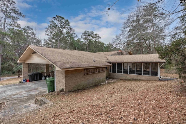 view of front facade with a carport and a sunroom