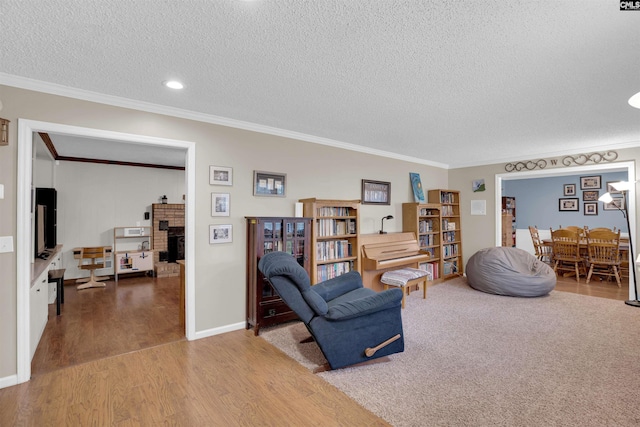 living room featuring a textured ceiling, ornamental molding, and hardwood / wood-style floors