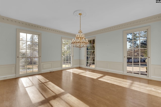 unfurnished dining area with hardwood / wood-style flooring and a chandelier