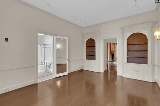 spare room with built in features, track lighting, and ornamental molding