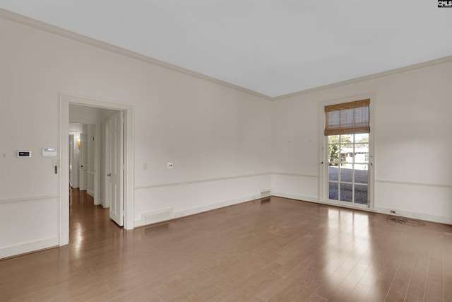 empty room featuring crown molding and hardwood / wood-style floors